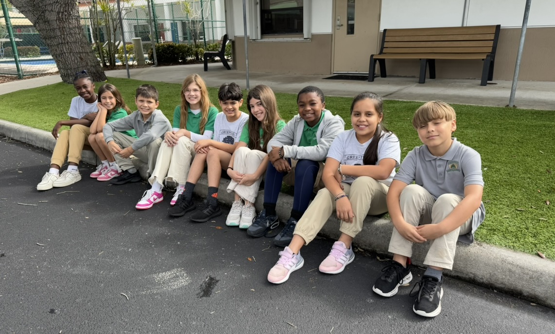 Greentree students sitting together outside the school